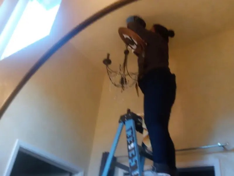 Electrician installing a chandelier in a Sinking Spring residence